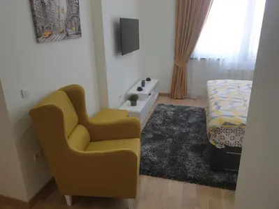 a bedroom with a yellow chair and a bed at Belgrade Waterfront-Delux apartman Beograd na vodi in Belgrade