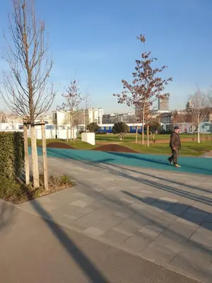 a man walking down a street next to a park at Belgrade Waterfront-Delux apartman Beograd na vodi in Belgrade