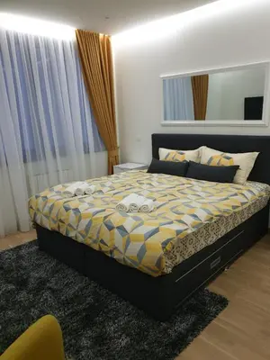 a bedroom with a bed with a yellow and blue comforter at Belgrade Waterfront-Delux apartman Beograd na vodi in Belgrade