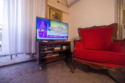a living room with a tv and a red chair at Stella Apartments in Belgrade