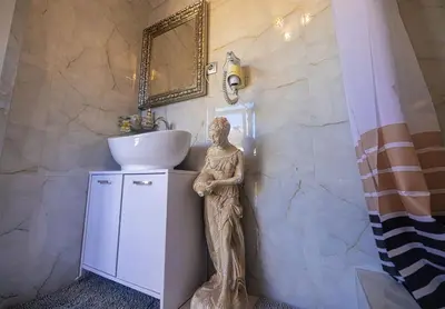 a statue of a woman standing next to a sink in a bathroom at Stella Apartments in Belgrade