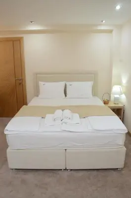 a large white bed with two towels on it at Stella Apartments in Belgrade