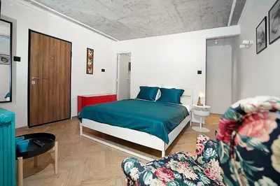 a bedroom with a bed and a couch and a chair at Tulum Apart Belgrade in Belgrade