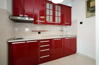 a kitchen with red cabinets and a sink at Tulum Apart Belgrade in Belgrade