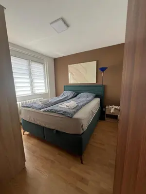 a bedroom with a bed with a blue headboard at Panorama View Belgrade in Belgrade