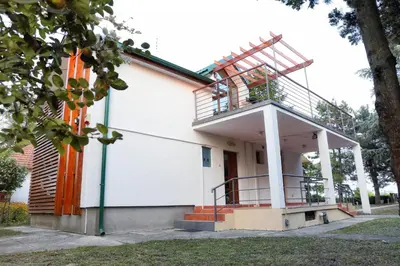 a building with a balcony on top of it at Belegis Villa in Stari Banovci