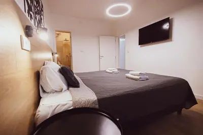 a bedroom with a bed with a tv on the wall at Viktor Luxury Suites in Belgrade