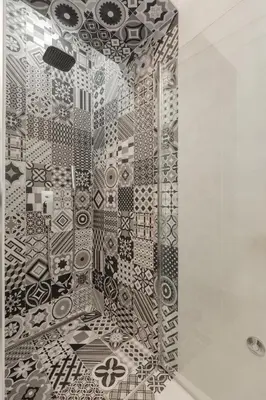 a shower with a black and white patterned wall at Viktor Luxury Suites in Belgrade