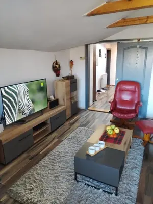 a living room with a television and a red chair at Apartment Viktor in Belgrade