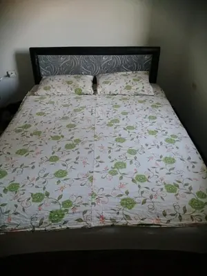 a bed with a bedspread with flowers on it at Apartment Viktor in Belgrade