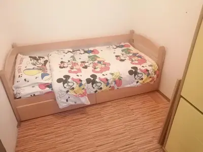 a small bed in a room with a box at Apartment Viktor in Belgrade