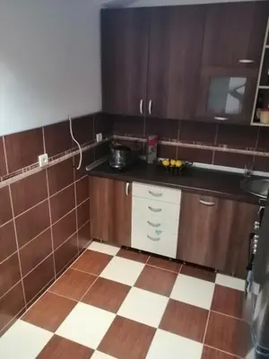 a kitchen with wooden cabinets and a tiled floor at Apartment Viktor in Belgrade