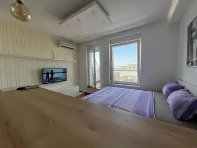 a bedroom with a bed and a large window at Hedonia in Belgrade