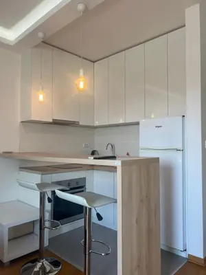 a kitchen with white cabinets and a white refrigerator at Hedonia in Belgrade