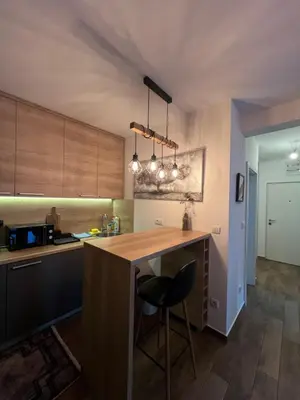 a kitchen with a wooden counter and a bar with a stool at LUX Apartment A&M Netflix in Belgrade