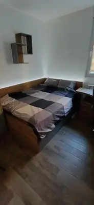 a bed in a bedroom with a checkered floor at LUX Apartment A&M Netflix in Belgrade