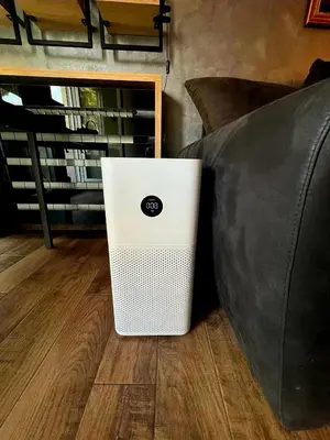 a white laptop sitting on the floor next to a couch at LUX Apartment A&M Netflix in Belgrade