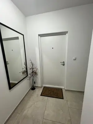 a white hallway with a mirror and a door at LUX Apartment A&M Netflix in Belgrade