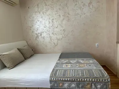 a bed in a room with a wall at Apartment Marina in Arandjelovac