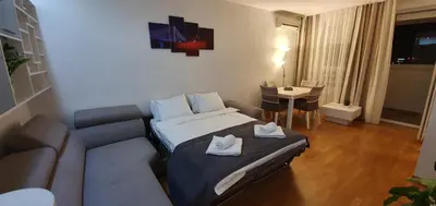 a hotel room with a bed and a couch at Royal apartment Belvill in Belgrade