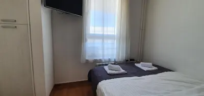 a small bedroom with a bed and a window at Royal apartment Belvill in Belgrade