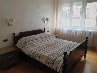 a bed in a bedroom with a large window at Metropol Lux apartment Belgrade Vracar in Belgrade