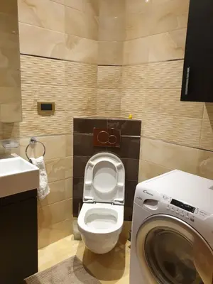 a bathroom with a toilet and a washing machine at Metropol Lux apartment Belgrade Vracar in Belgrade