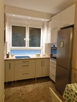 a kitchen with white cabinets and a stainless steel refrigerator at Metropol Lux apartment Belgrade Vracar in Belgrade