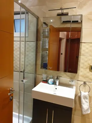 a bathroom with a sink and a shower with a mirror at Metropol Lux apartment Belgrade Vracar in Belgrade