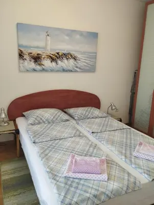 a bed in a bedroom with a picture of a lighthouse at Vlado apartment VS in Belgrade