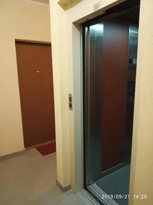 a glass elevator in a building with a door at Vlado apartment VS in Belgrade