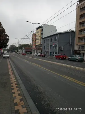an empty city street with cars parked on the road at Vlado apartment VS in Belgrade