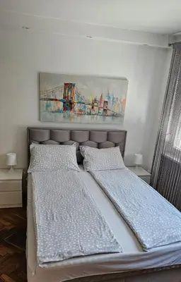 a bedroom with two beds and a painting on the wall at Sweet Home in Belgrade
