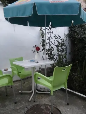 a table with two green chairs and an umbrella at Gardos dupleks in Belgrade