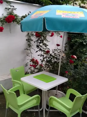 a table and four chairs under an umbrella at Gardos dupleks in Belgrade