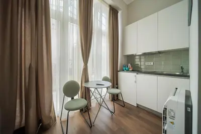 a kitchen with a table and chairs and a window at Slavija Fontana Lux Apartments in Belgrade