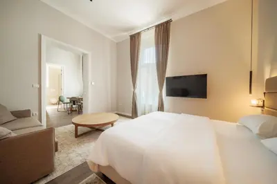 a bedroom with a large white bed and a couch at Slavija Fontana Lux Apartments in Belgrade