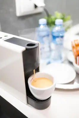 a coffee maker is making a cup of coffee at Slavija Fontana Lux Apartments in Belgrade