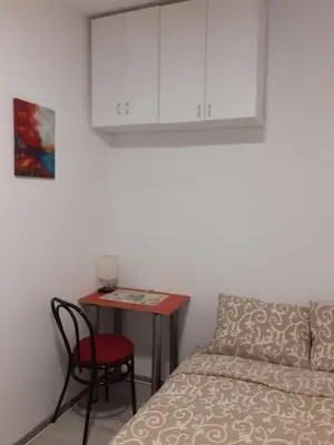 a bedroom with a bed and a table with a chair at Studio Krunska 6 in Belgrade