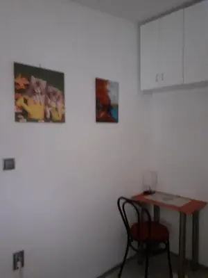 a table and a chair next to a white wall at Studio Krunska 6 in Belgrade