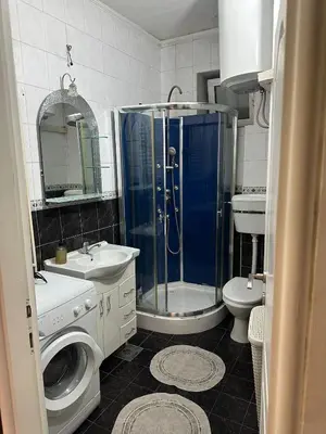 a bathroom with a shower and a toilet and a sink at Savski Square Suites in Sajmište