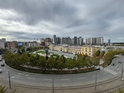 an empty street in a city with buildings and trees at Savski Square Suites in Sajmište