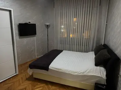 a bedroom with a bed and a flat screen tv at Savski Square Suites in Sajmište