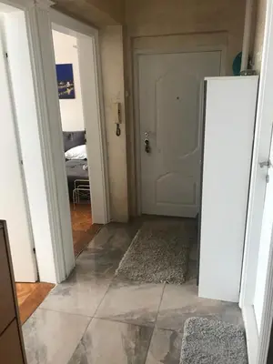 a hallway with a white door and a tile floor at Savski Square Suites in Sajmište