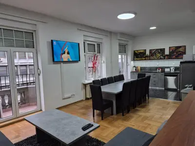 a living room with a table and chairs and a kitchen at Authentic Belgrade Centre Apartment #2, Four Bedrooms, One full Bathroom, One Toilet in Belgrade