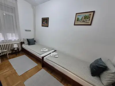 a living room with two beds and a window at Authentic Belgrade Centre Apartment #2, Four Bedrooms, One full Bathroom, One Toilet in Belgrade