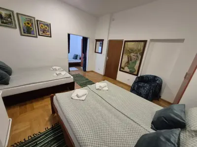 a room with two beds and a chair in it at Authentic Belgrade Centre Apartment #2, Four Bedrooms, One full Bathroom, One Toilet in Belgrade