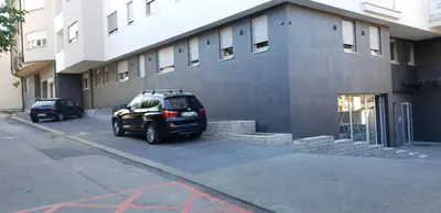 a car parked in a parking lot next to a building at Apartment Story,Nikole Cupica Beograd in Belgrade