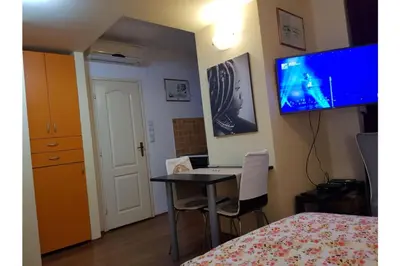 a bedroom with a desk and a tv on the wall at Bella Centre Apartment in Belgrade