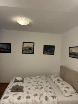 a bed in a bedroom with pictures on the wall at Bella Centre Apartment in Belgrade